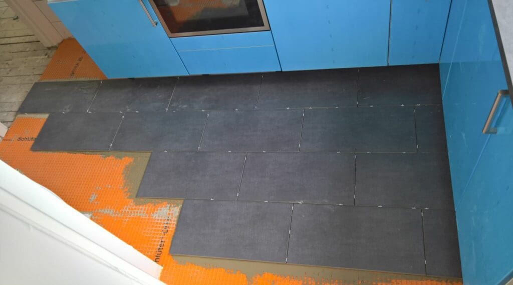 tegelen over Ditra 25 polyethyleen mat op houten vloer in keuken